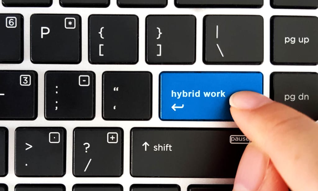 A keyboard where the enter button is being pressed to show hybrid work model examples.