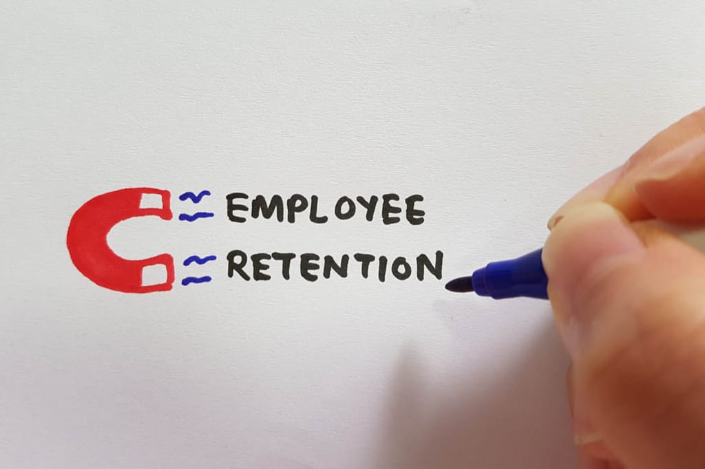 A drawing of a magnet with the words ‘employee retention’ being pulled to it to signify attrition rate.