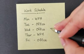An employee writing out their hybrid work schedule for the week.