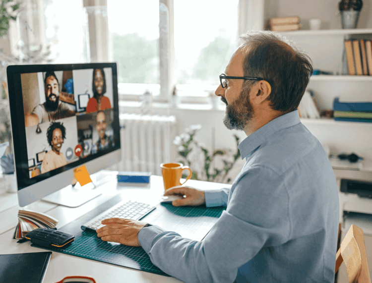 A man having a Zoom meeting with 4 people from his home office, while using remote workforce management software.