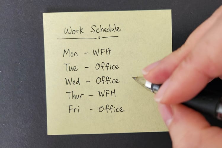 An employee writing out their hybrid work schedule for the week.