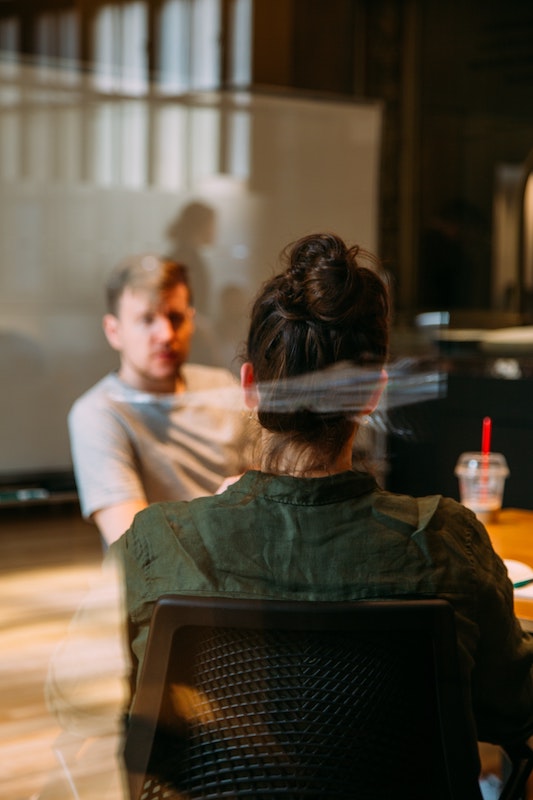 person sitting in a chair in front of a man being coached