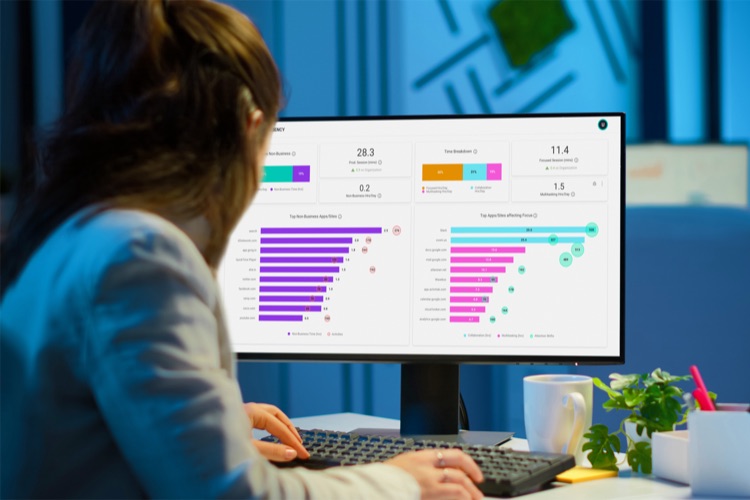 A woman pointing to charts and reports showing productivity trend last 12 complete weeks with a lightbulb and gear icons.