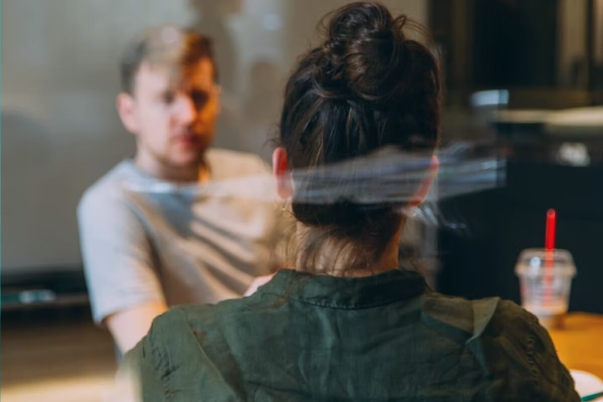 A manager and employee sitting at a table listening to the employee’s concerns about their workplace.