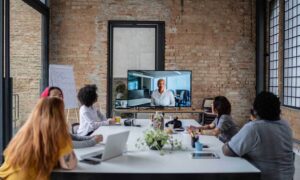 A team conducting a meeting with remote coworkers using remote work software.