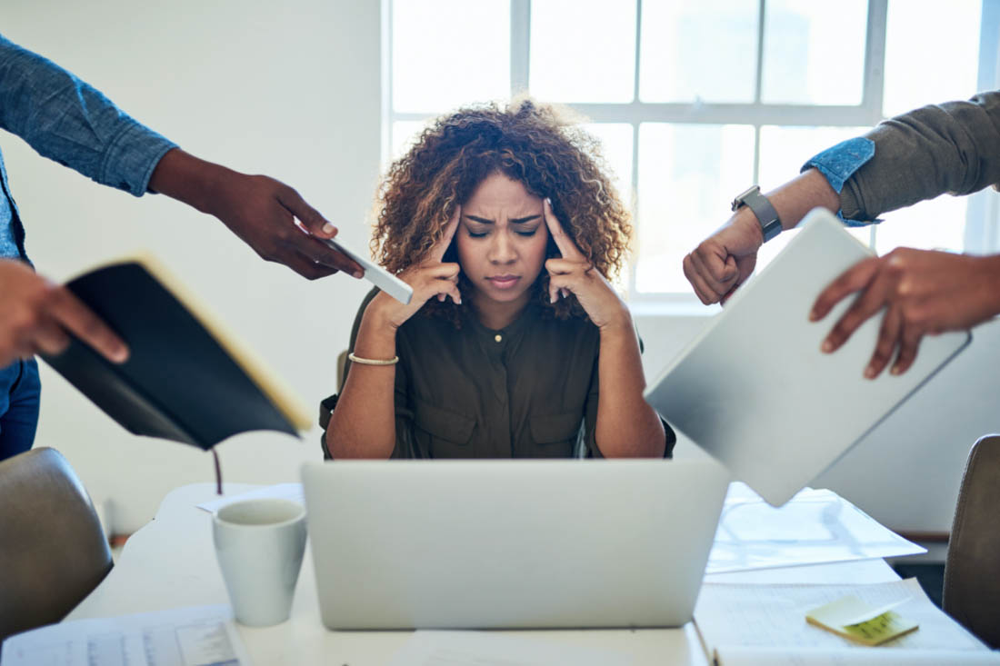 A burned out employee being bombarded with tasks, which begs the question, how is productivity affected when employees multitask?