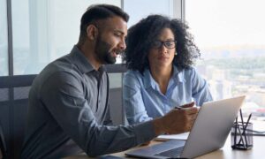 two employees discussing how to monitor employee performance data.
