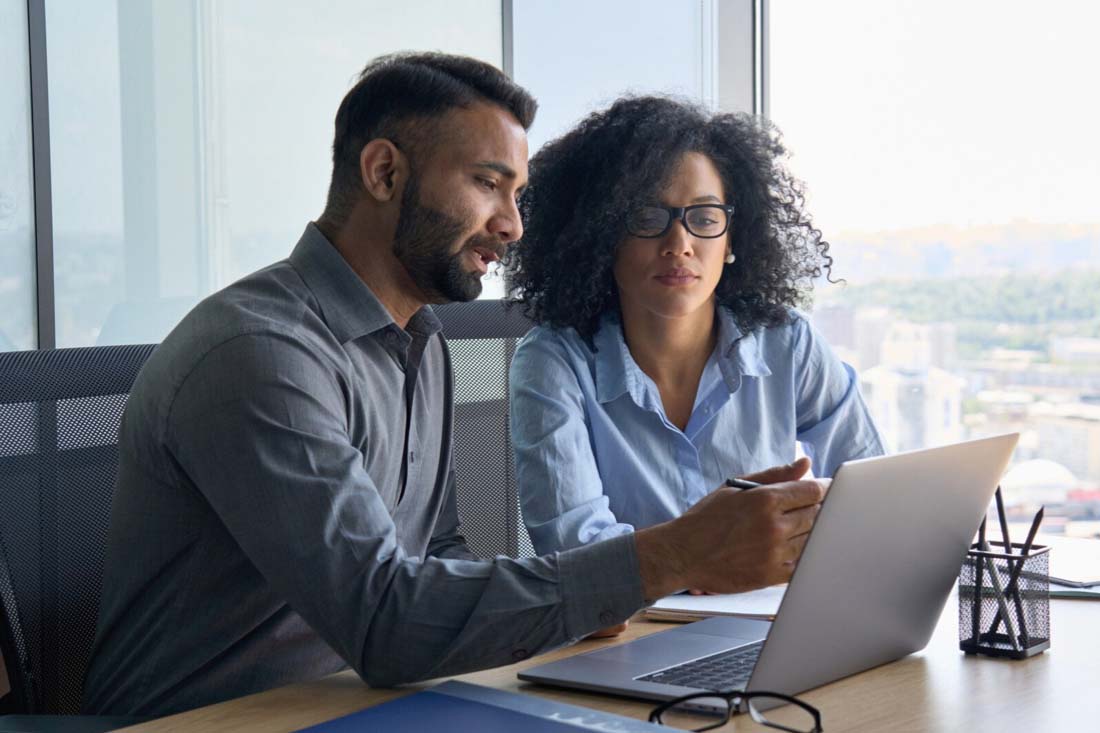 two employees discussing how to monitor employee performance data.