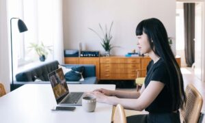 A female employee working remotely while trying to understand how to improve remote work productivity.
