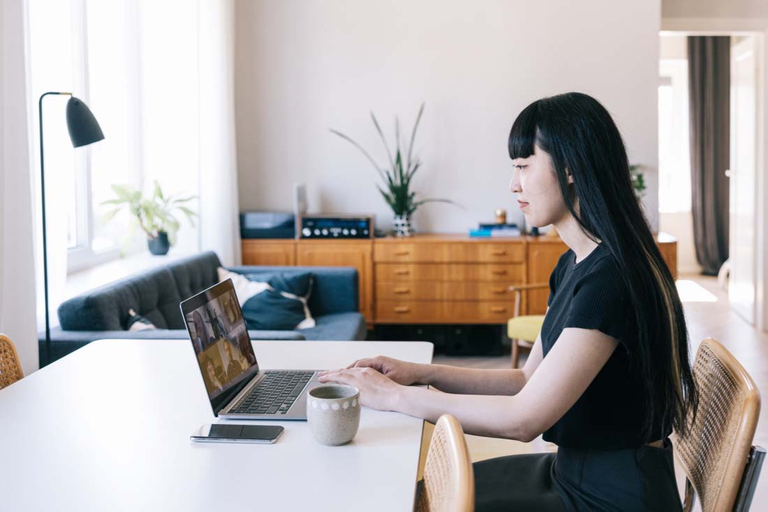 A female employee working remotely while trying to understand how to improve remote work productivity.