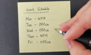 An employee writing out their hybrid work schedule for the week.