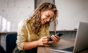 An employee on their personal phone during company time, which asks the question: how to prevent misuse of technology?