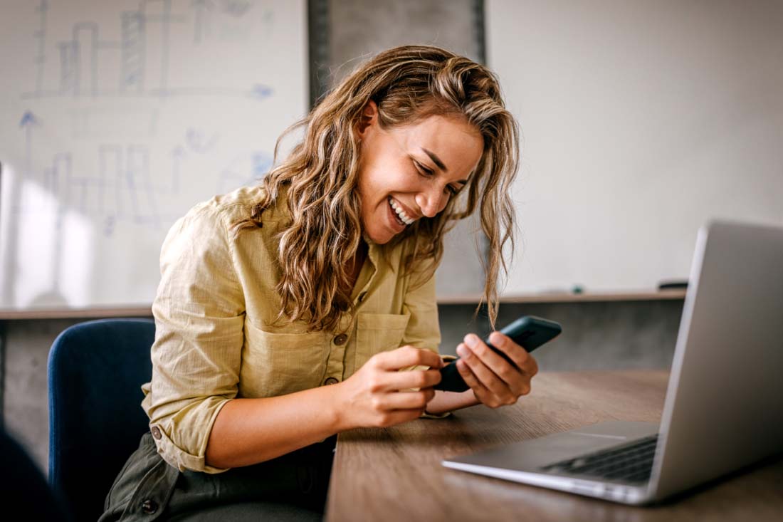 An employee on their personal phone during company time, which asks the question: how to prevent misuse of technology?