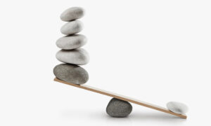 A stone and wooden plank being used to balance rocks between two sides, though there is a clear imbalance