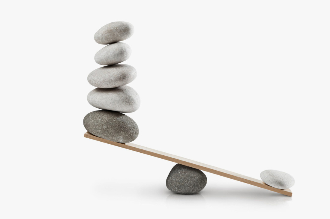 A stone and wooden plank being used to balance rocks between two sides, though there is a clear imbalance