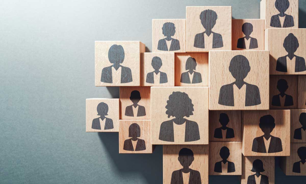 Wood blocks with employees on them to symbol developing a workforce optimization plan.