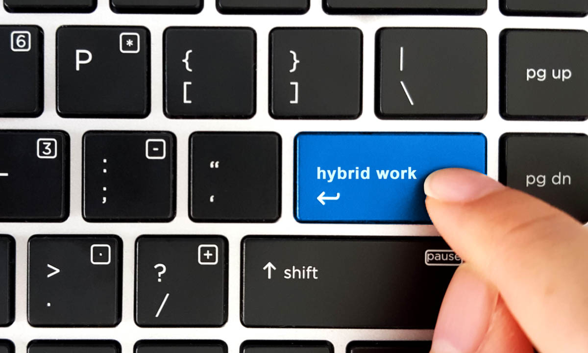 A keyboard where the enter button is being pressed to show hybrid work model examples.