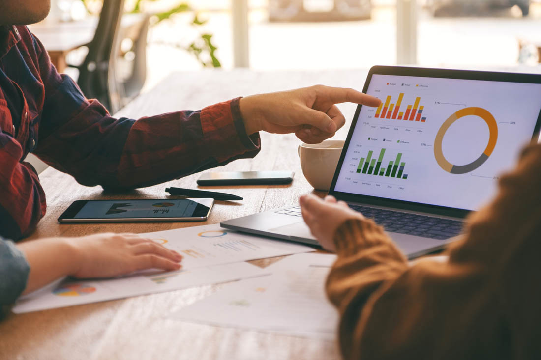 Two employees that work in a data culture discussion with data shown on a laptop