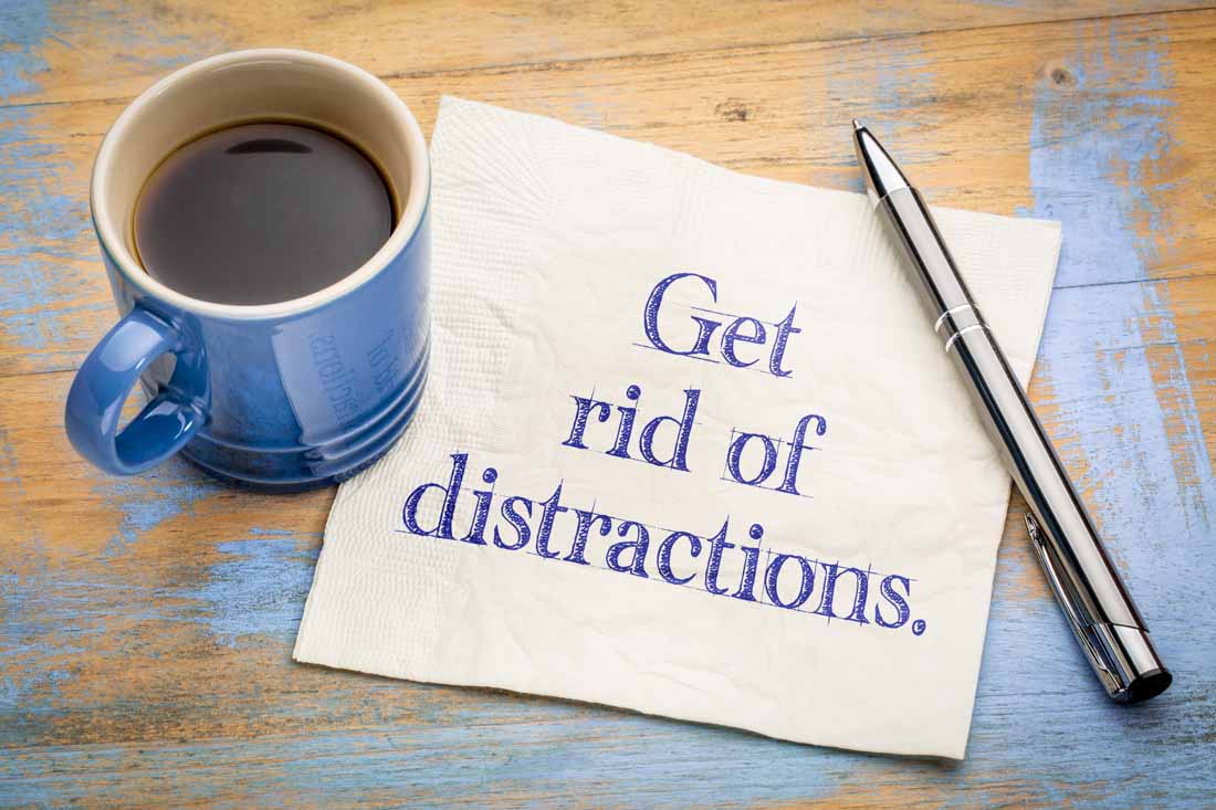 A coffee cup and a piece of paper that says “get rid of distractions”