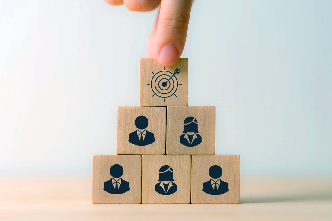 Employee icons on wooden blocks stacked.