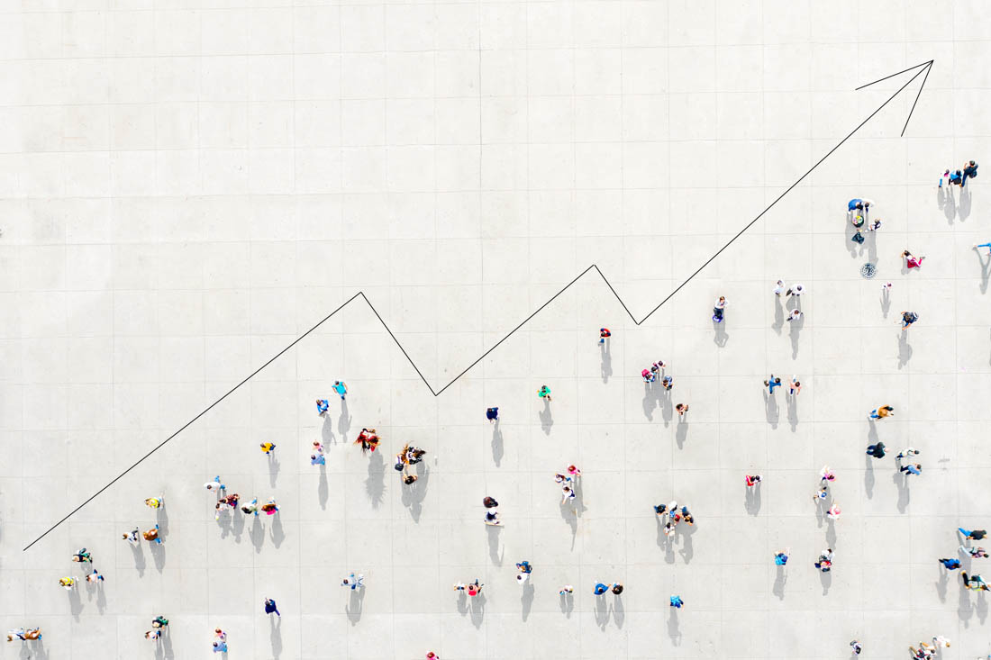 A picture of a chart trending up and to the right, with people filling in the space under the bar to symbolize the benefits of people analytics.