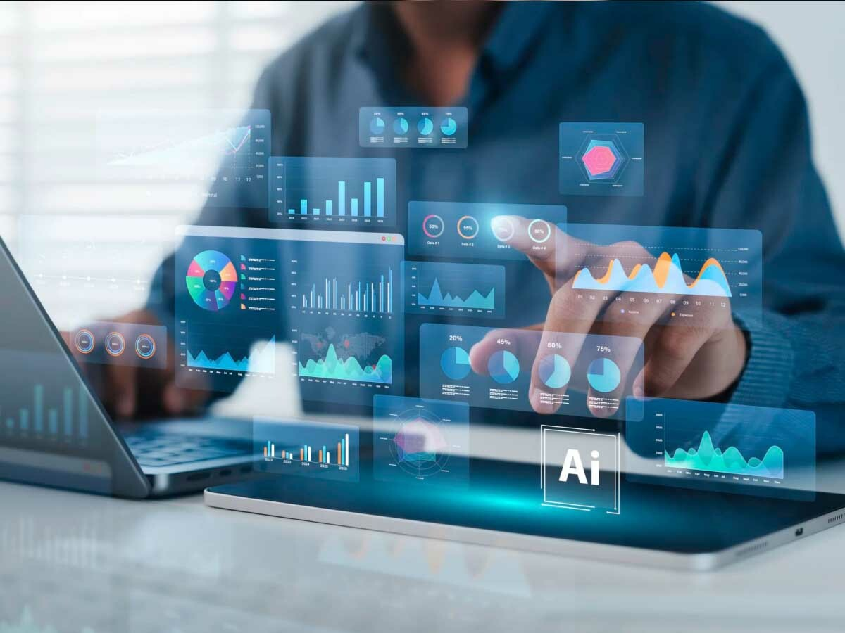 Executive in front of laptop with projections of AI adoption and impact charts and graphs.