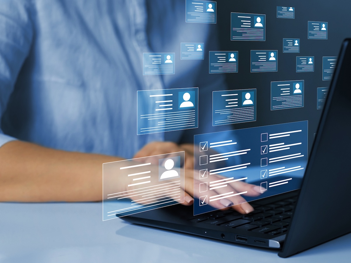 Person typing on a laptop with floating digital profile icons and checklists, suggesting data management or online profiles, conveying efficiency.