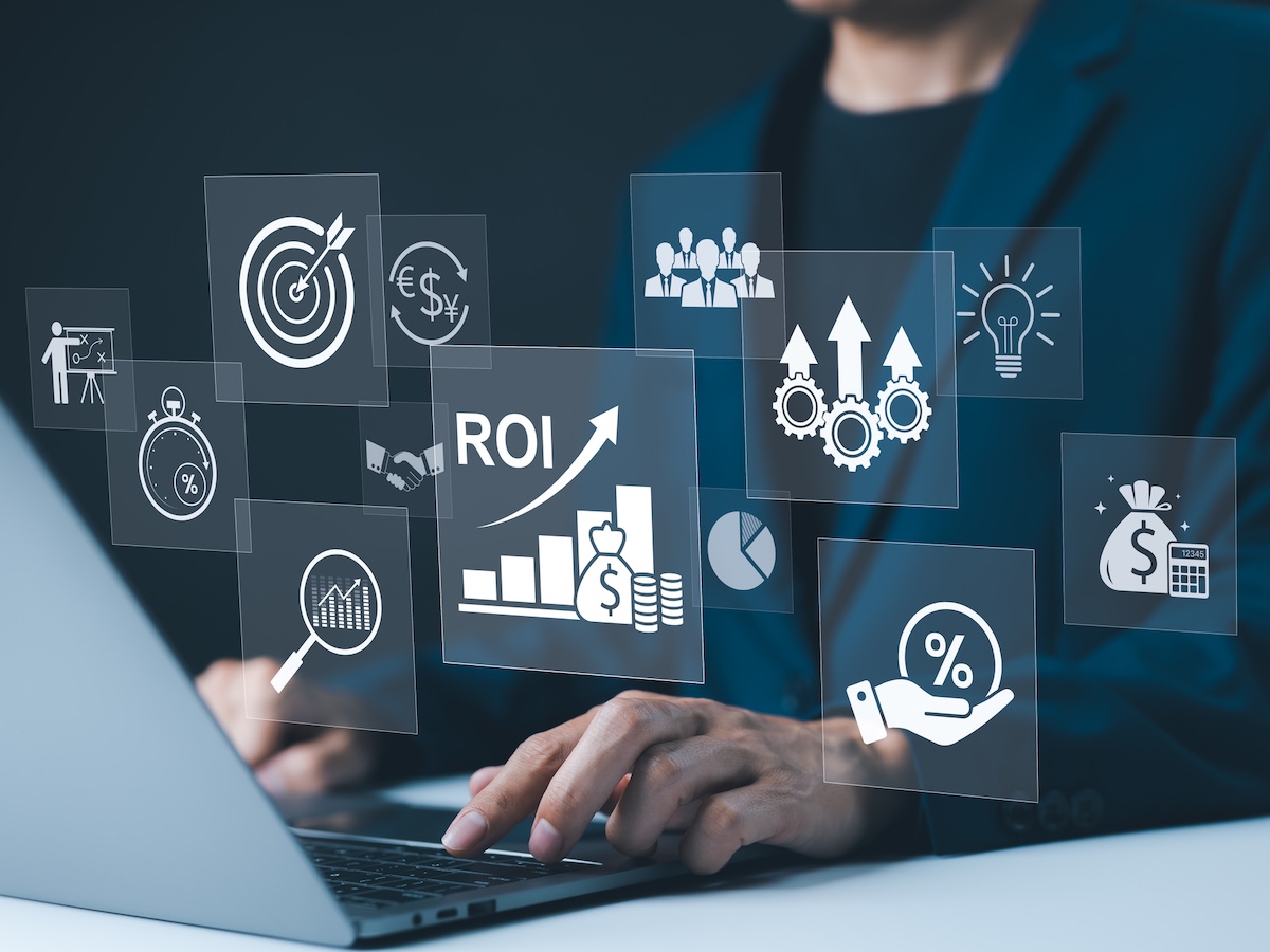 Person typing on a laptop, surrounded by virtual icons including ROI, gears, target, pie chart, and dollar bag, conveying business growth.